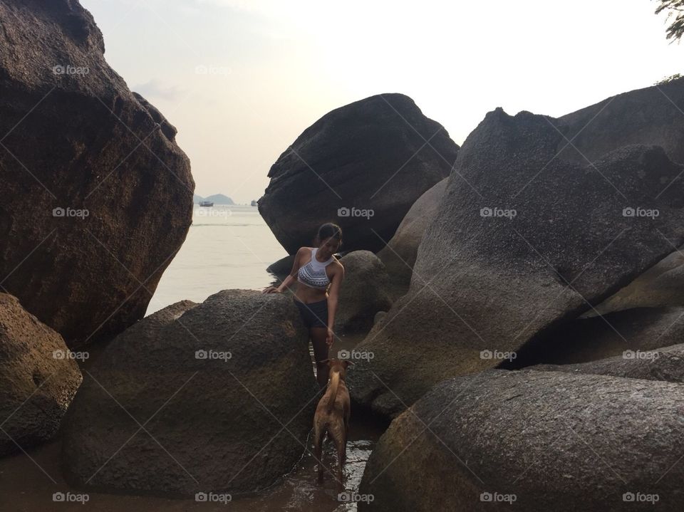 young Asian girl playing with dog on the beach in Koh Tao island,Thailand 