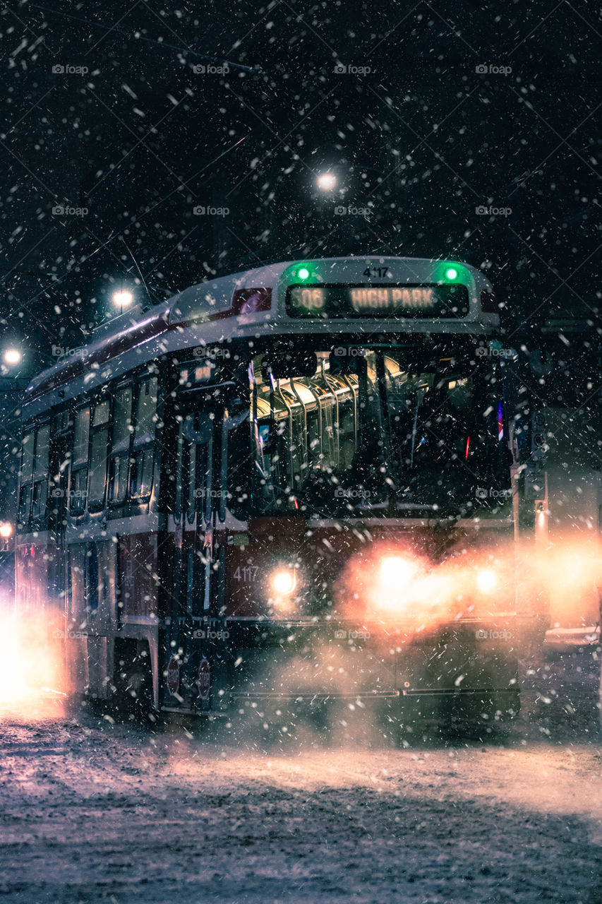 A street car in Toronto active on a cold snowy winter night. 506 line to High Park