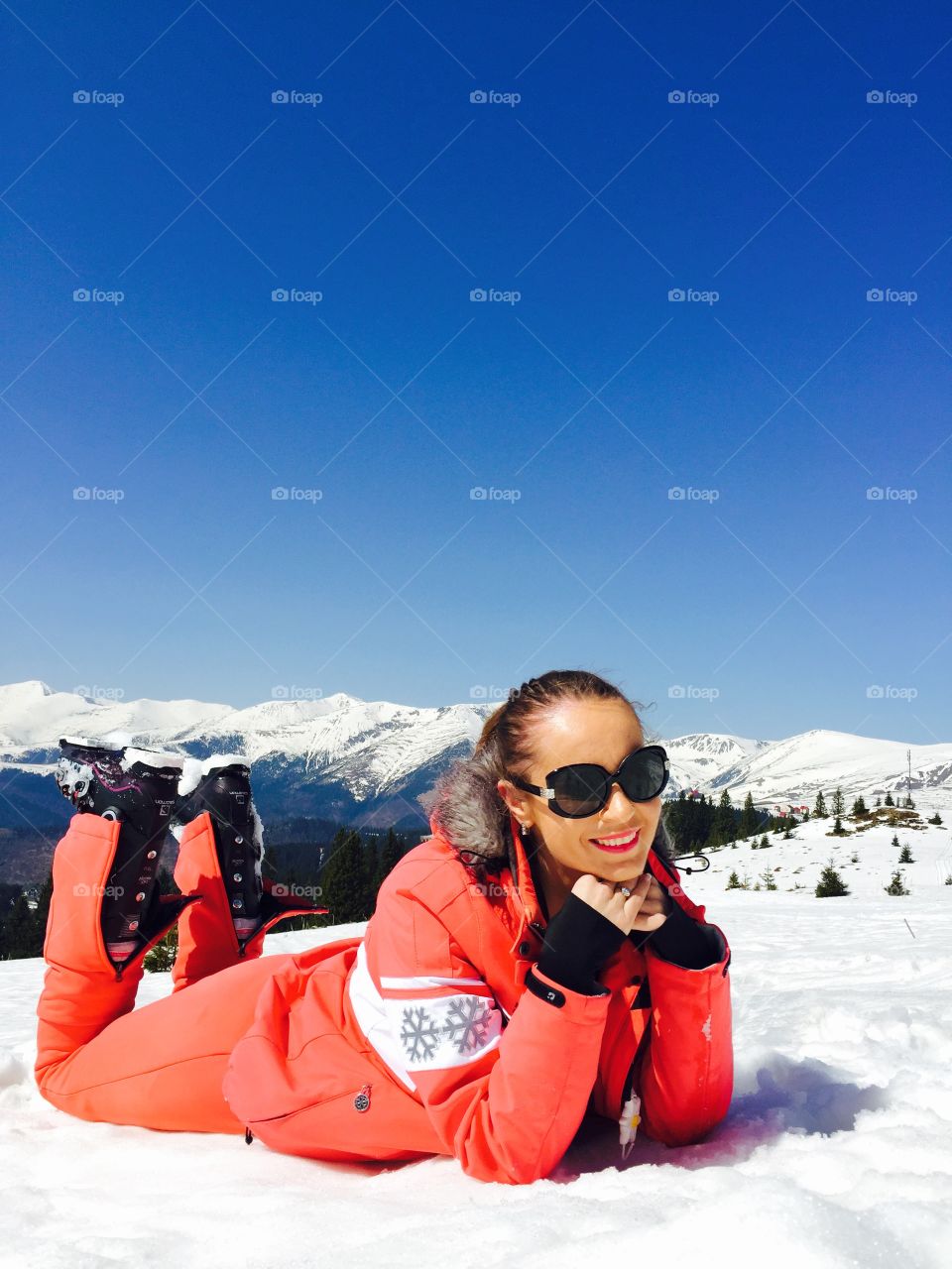 Woman lying on snowy land during winter