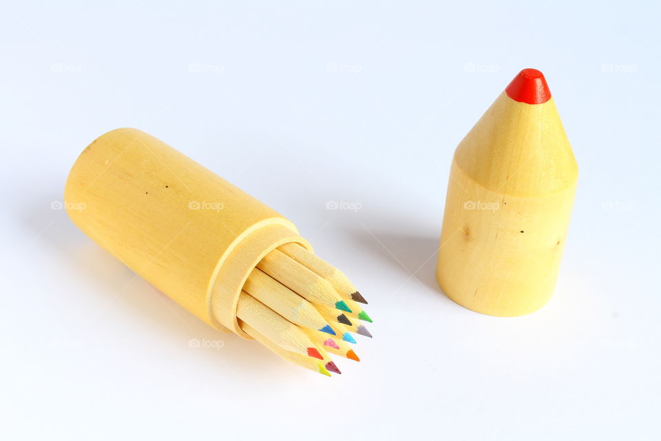 Group of color crayons in a wooden cylinder isolated macro