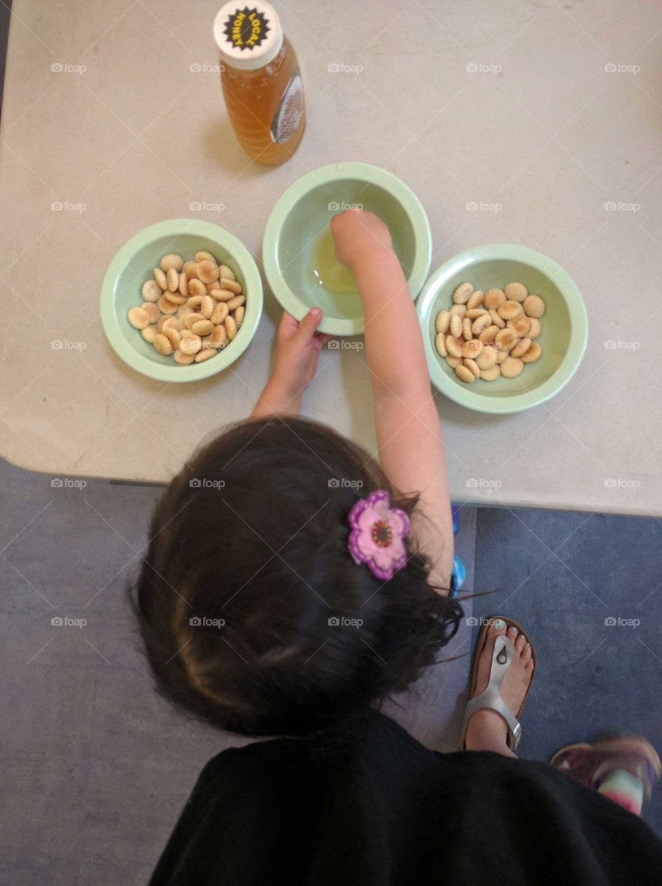 Small child samples different flavors of honey.