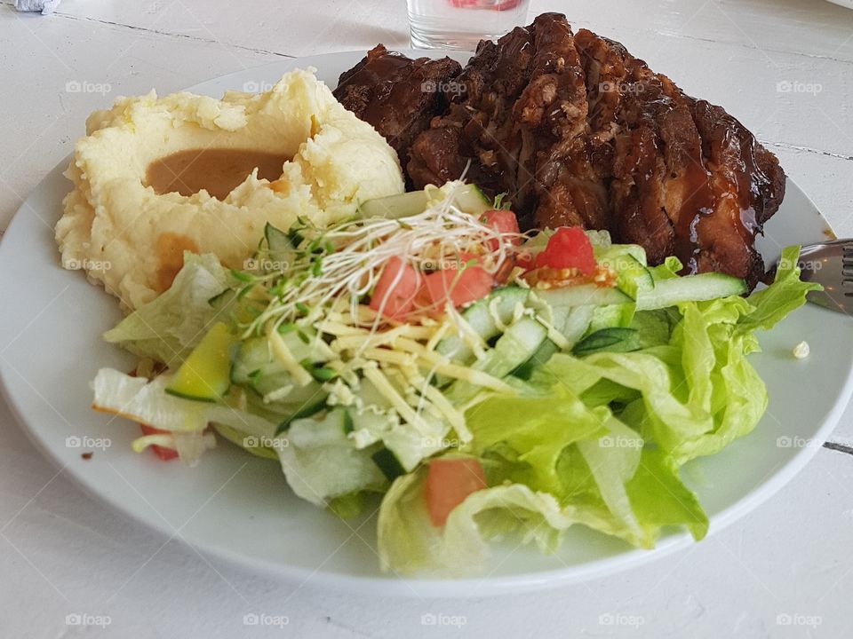 complete meal for the day. mashed potato, oven baked ribs, vegetable salad. healthy meal specifically for lunch. deliciously healthy.