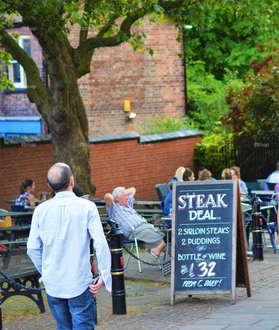 People enjoying the good weather outside the pub. Ye olde trip to Jerusalem oldest inn pub in England, 1189 building  Nottingham, UK