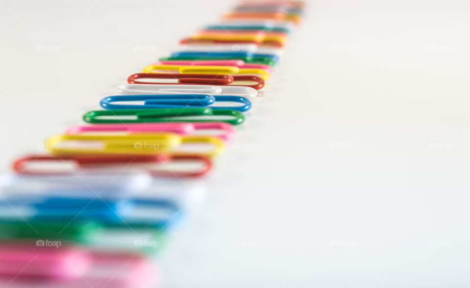 Multi coloured paper clips in white background