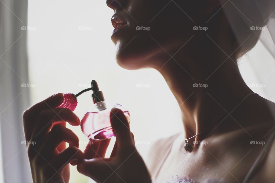 Woman spraying perfume on her neck