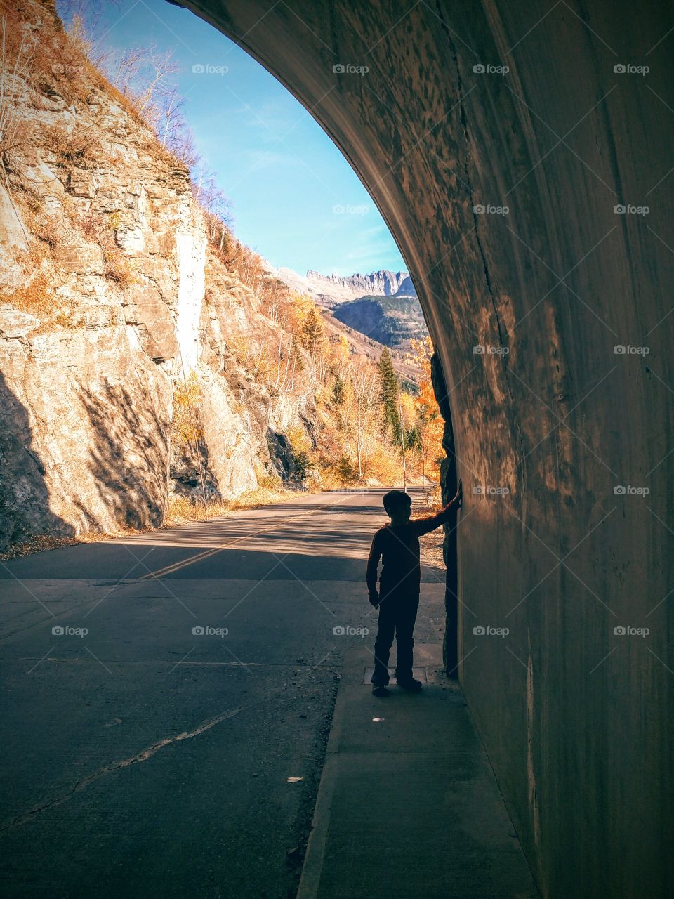 Fall, Silhouette of a boy in a tunnel, Glacier National Park, MT