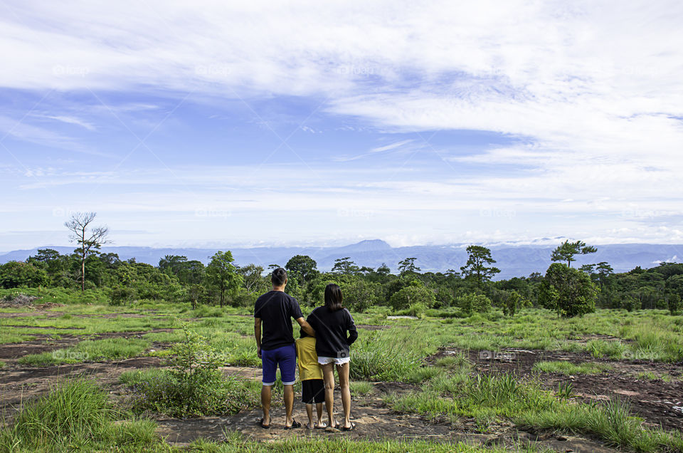 Father and mother hugged their son and looked at the mountains and trees at Phu Hin Rong Kla National Park , Phetchabun in Thailand.