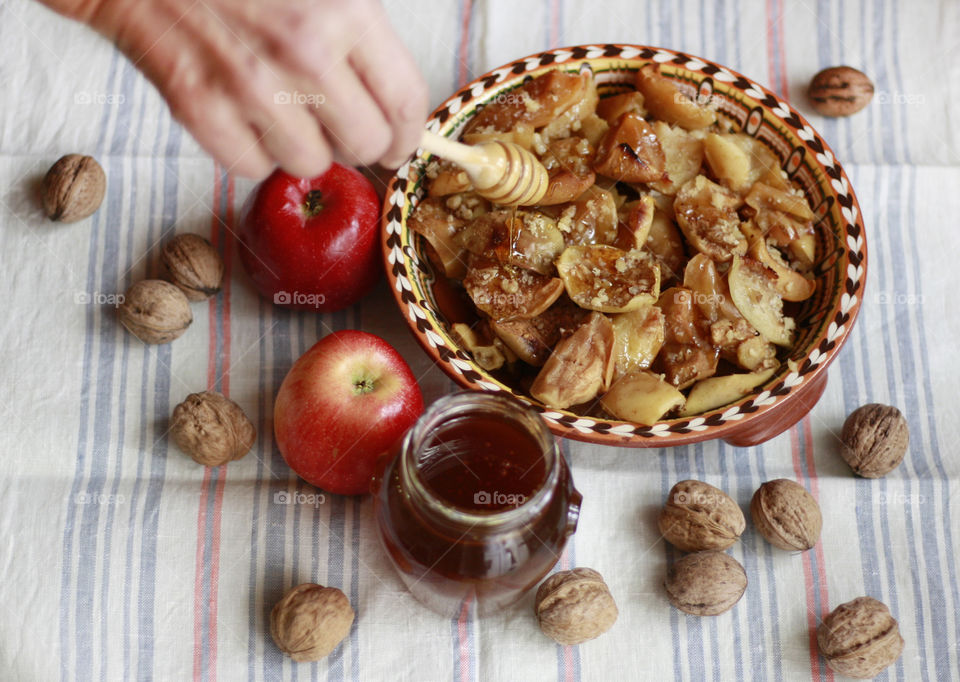 Cooking at home, autumn food, preparing baked apples with honey and walnuts