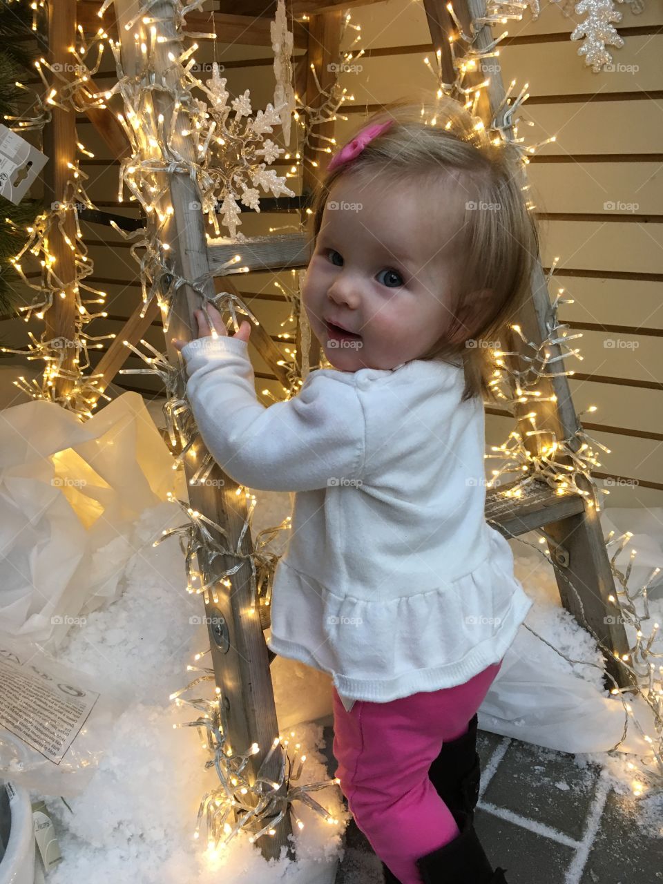 Baby surrounded by Christmas lights