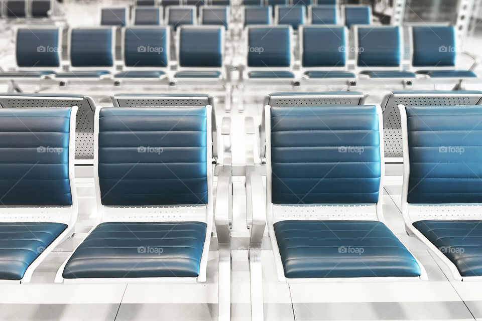 Many blue symmetrical seats at the airport 