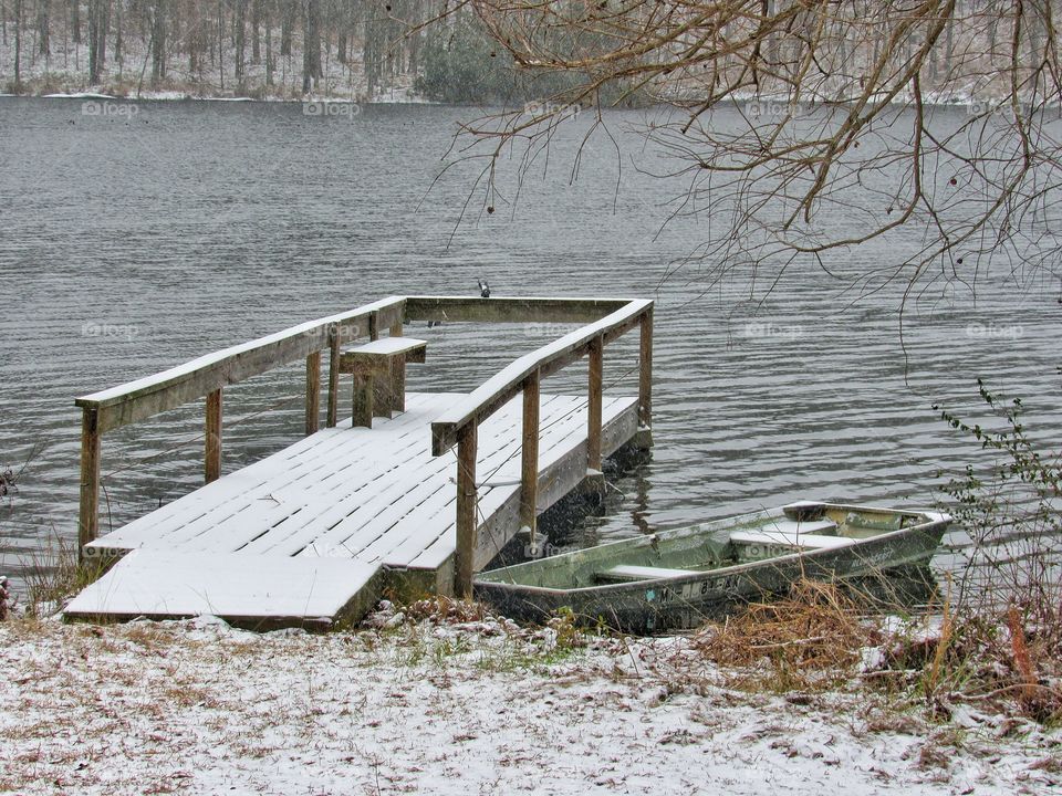 boat in water beside dock with snow outdoors