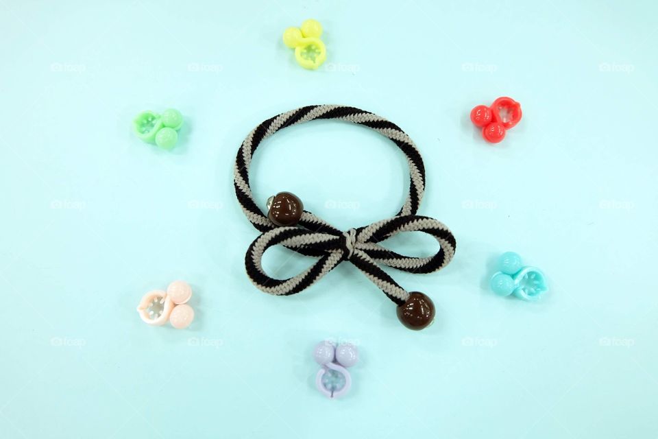 Brown Hair Rubber Band with Pearl Fashion Accessories. Top View. Rubber Band with Colorful Hair Clip Isolated on Blue Background Great for Any Use.
