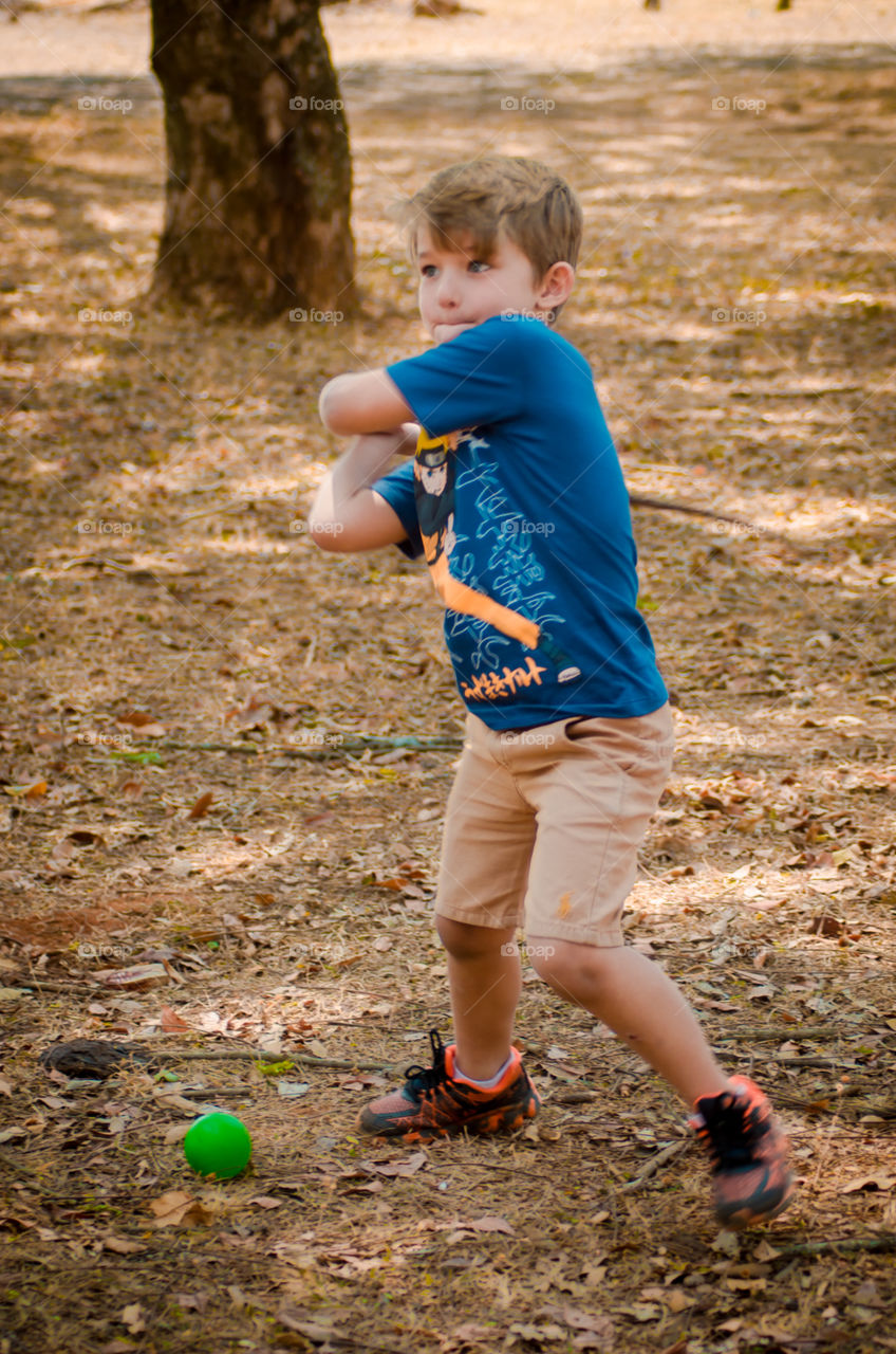 pretty child playing bete with tree stick