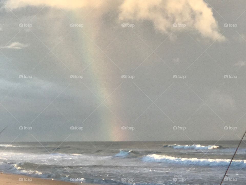 Rainbow within storm rolling in off the ocean