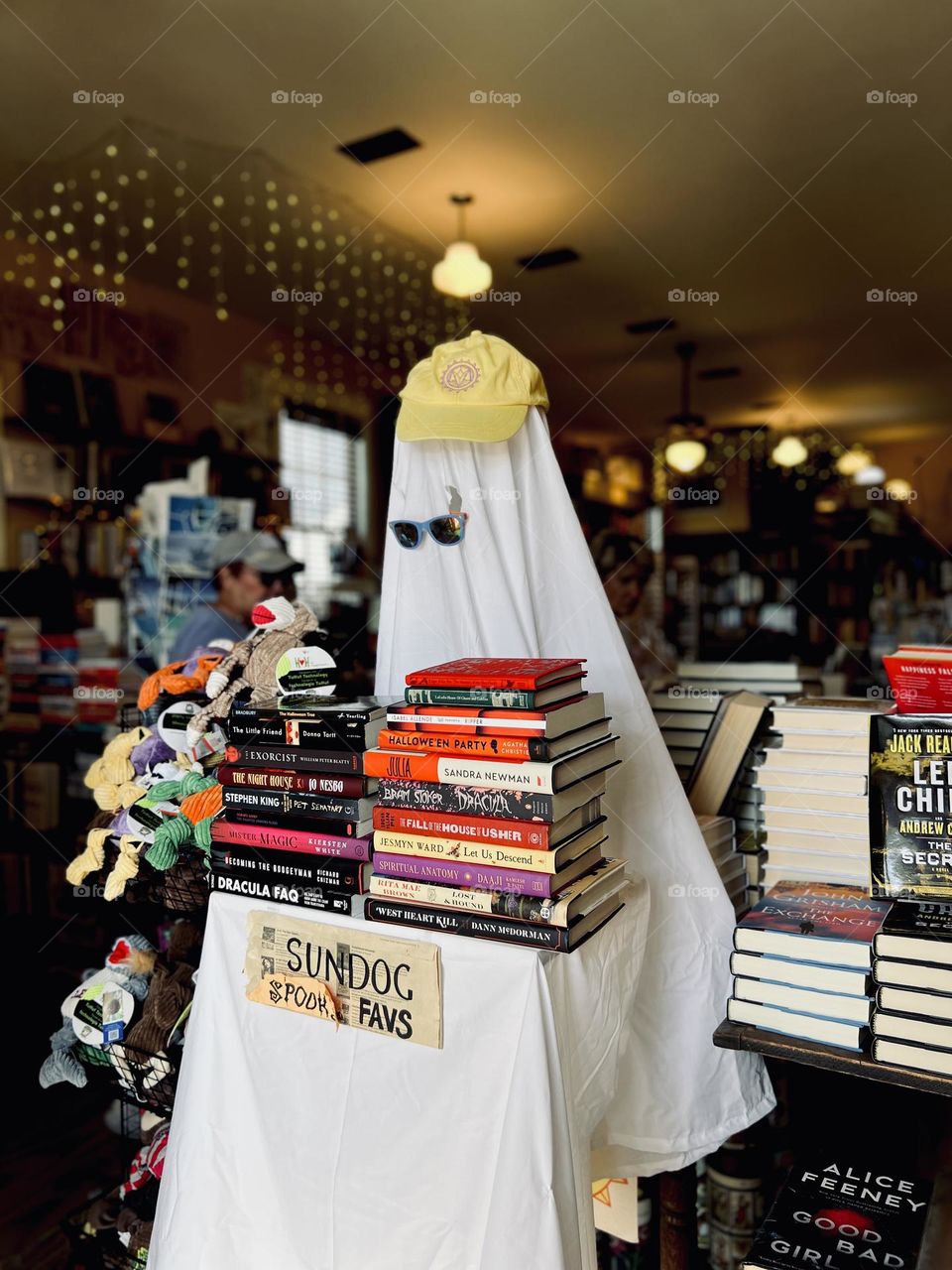 Halloween decorations in a bookstore. Ghost wearing sunglasses and a cap, holding spooky books