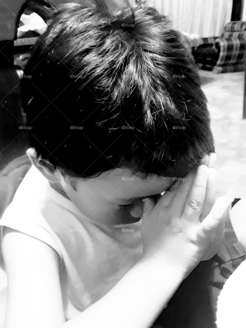 A toddler praying before meals.