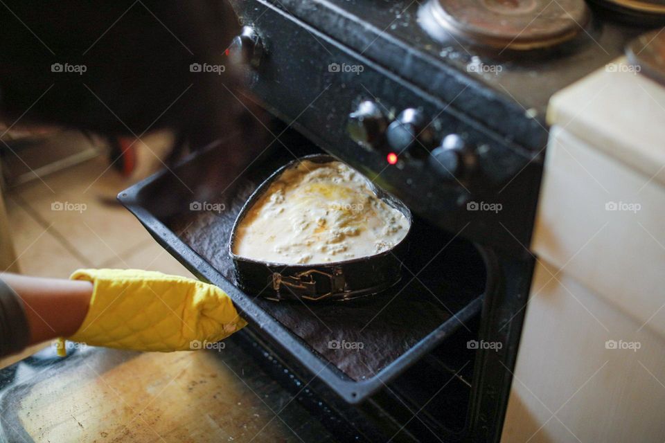 Metal baking mold in the shape of a heart and a stove