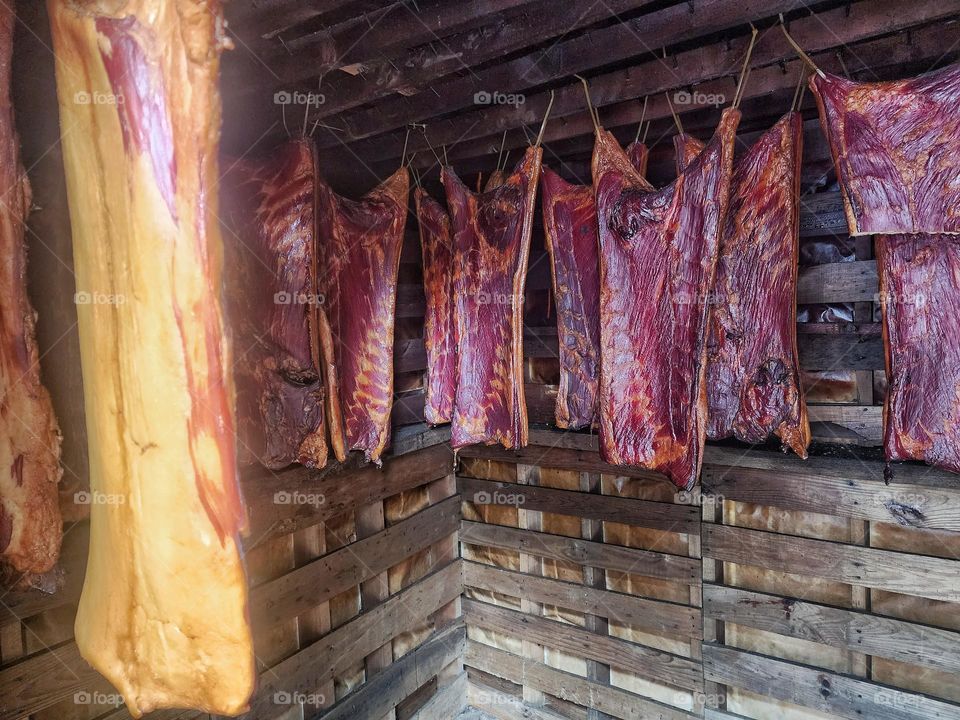 Meat hanging in a smokehouse.