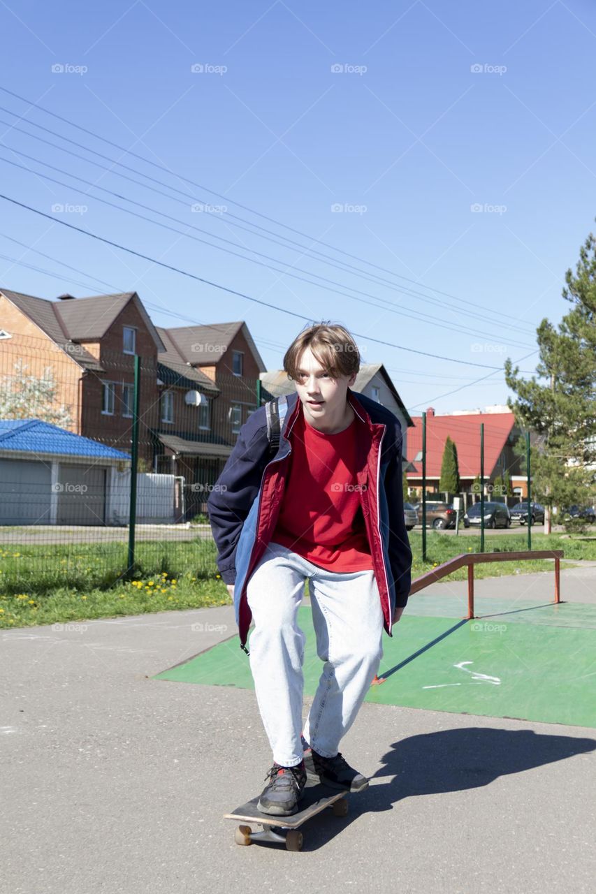 Hobbyist teenager goes in for sports, has fun and rides a skateboard in the park outdoors.