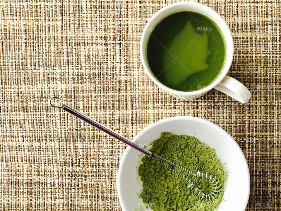 Green tea match in a bowl on wooden