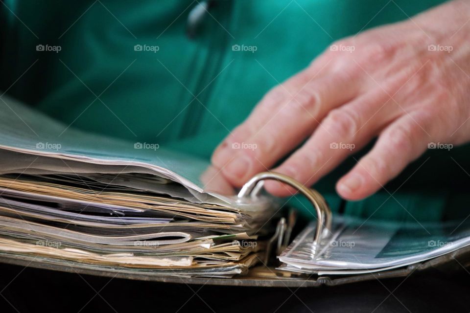 Close-up of a man's hand leafing through a folder