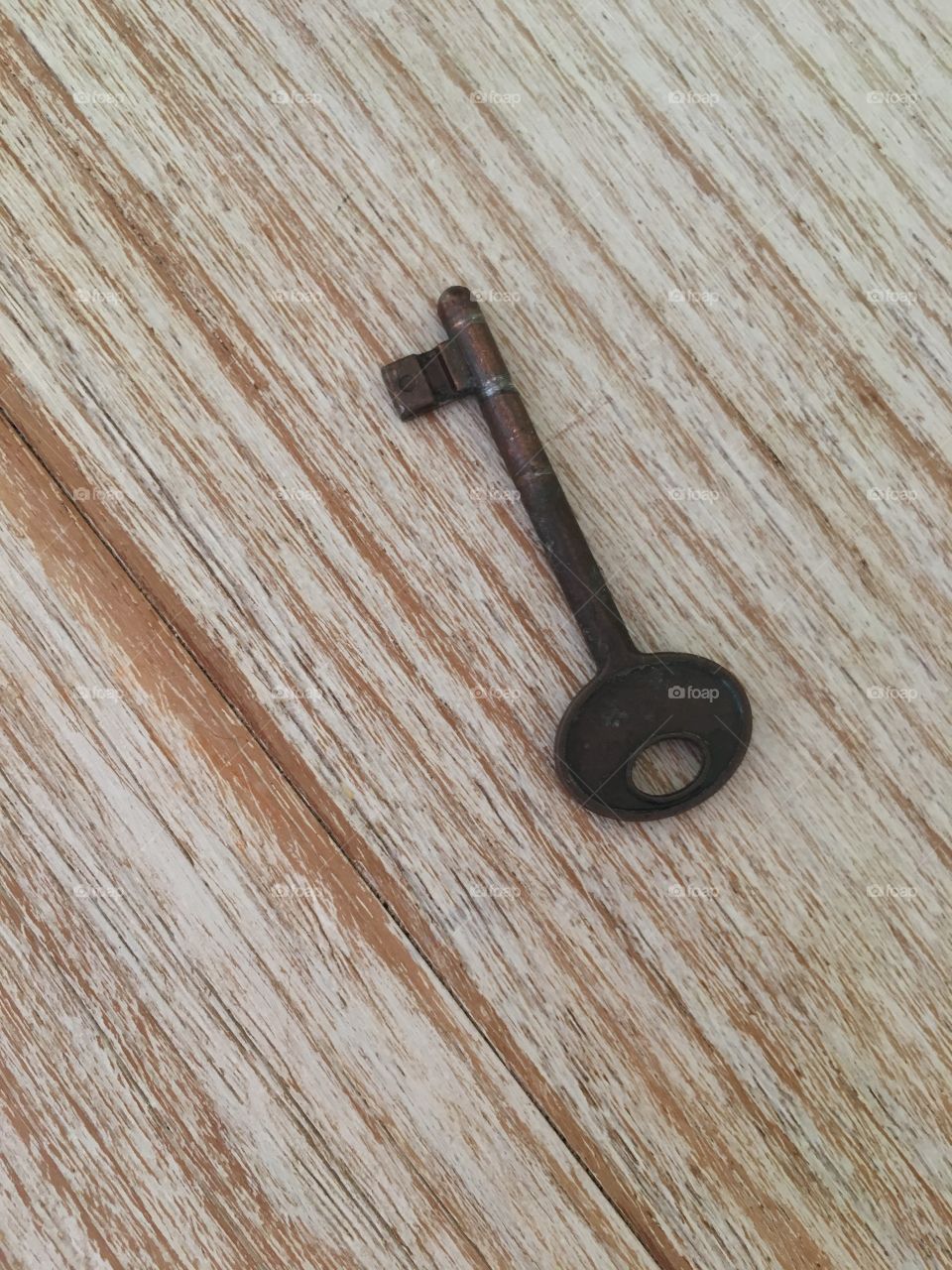 Old metal key on wooden table