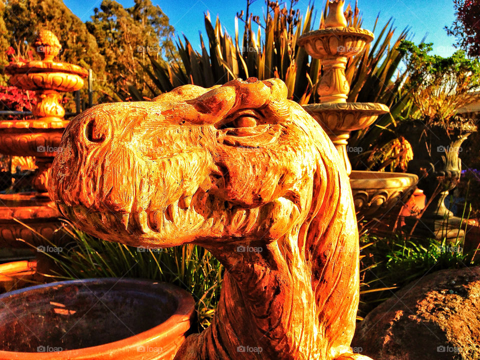 Dinosaur garden statue in the hot orange dry sunset of California