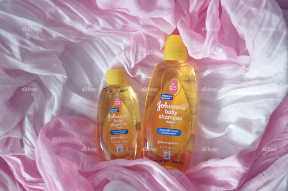 Johnson and Johnson baby shampoo on a pink background flat lay 
