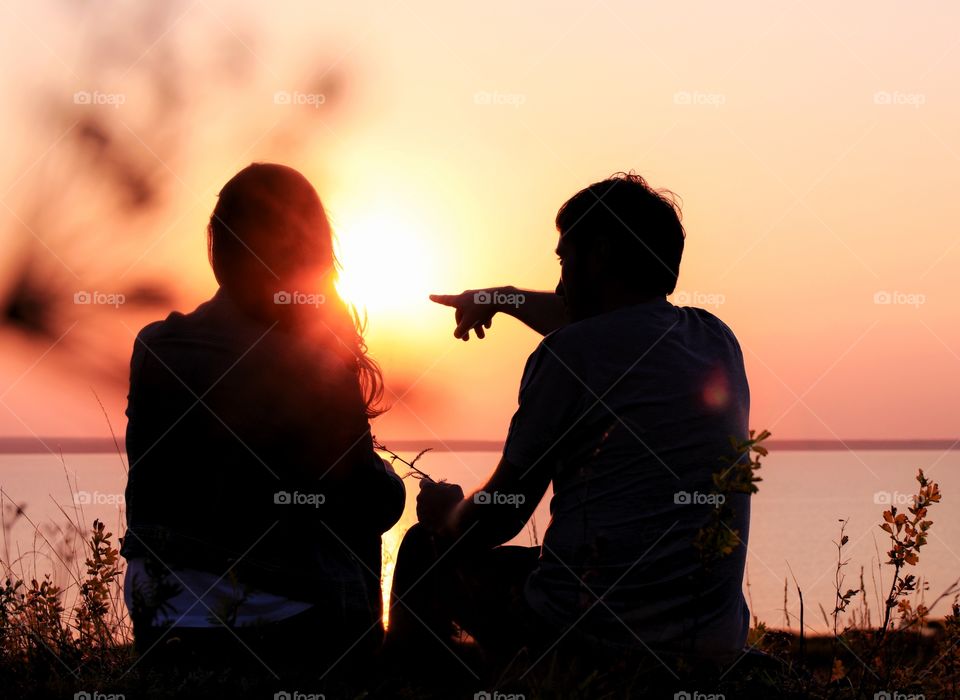 Silhouette man and woman on the sunset 