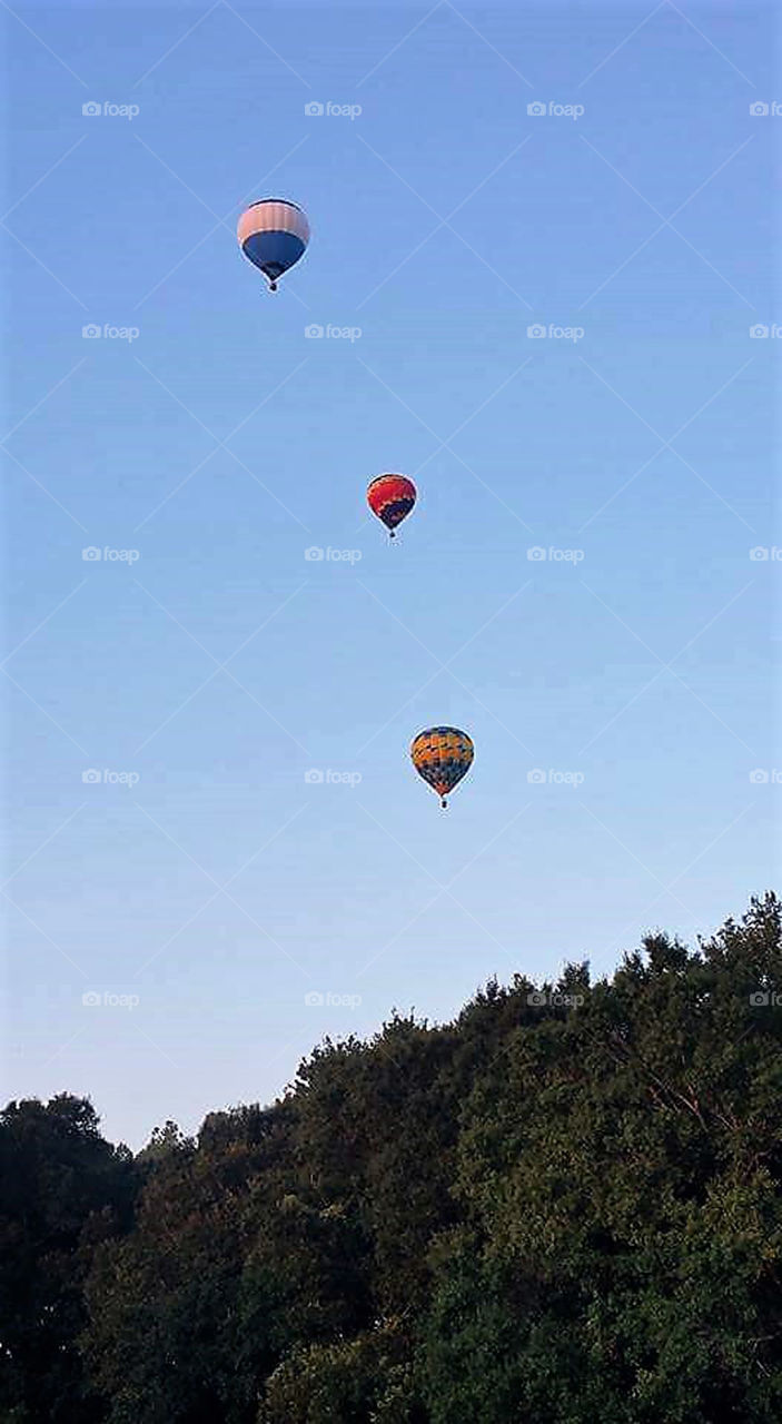 Three colorful balloons with blue sky background