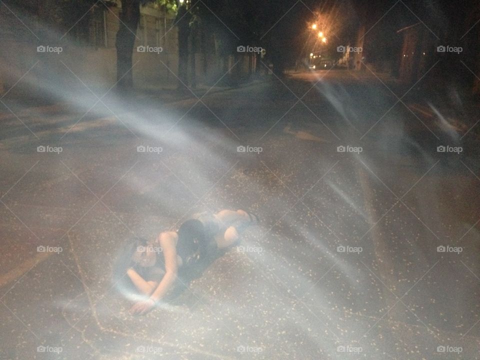 Woman lying on road at night