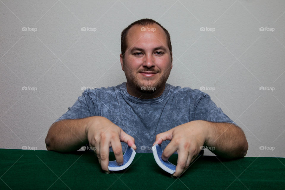Man shuffling cards. This is a photograph of a man shuffling cards.