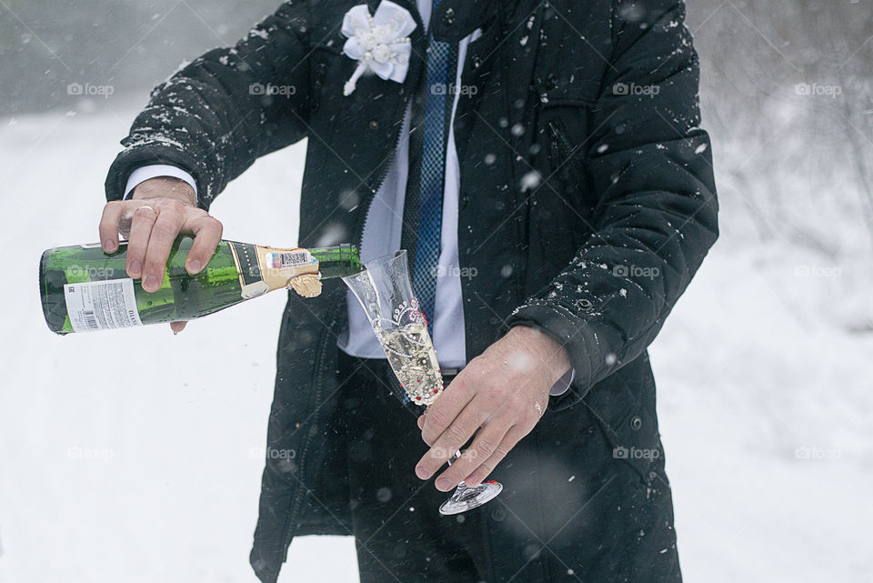 groom pouring champagne