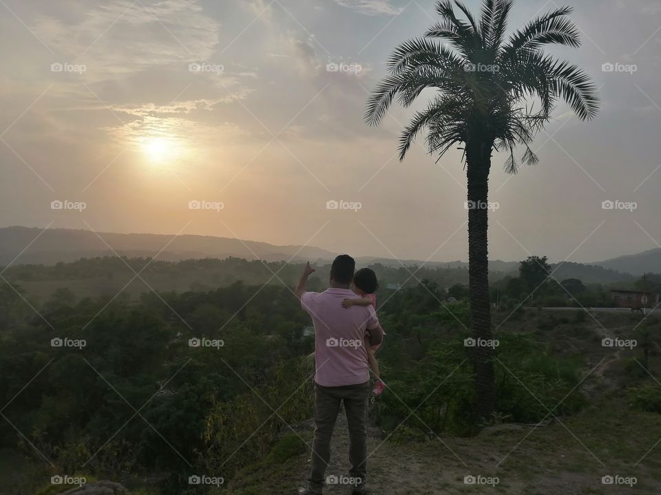 FATHER TRY TO UNDERSTAND HER BABY GIRL DURING BEAUTIFUL SUNSET IN SUMMER.