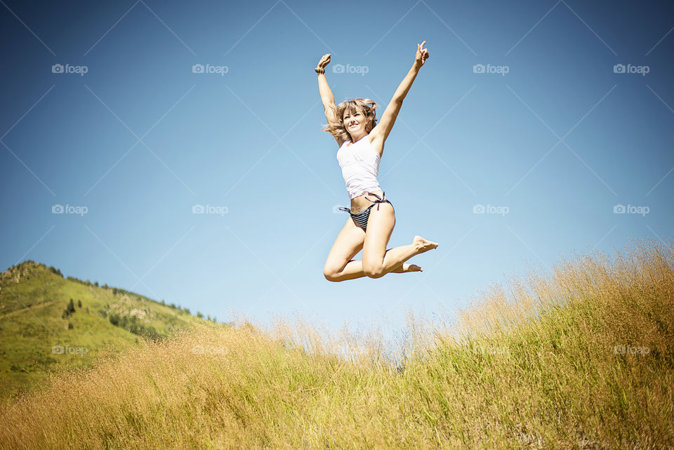 Woman jumping over the grass