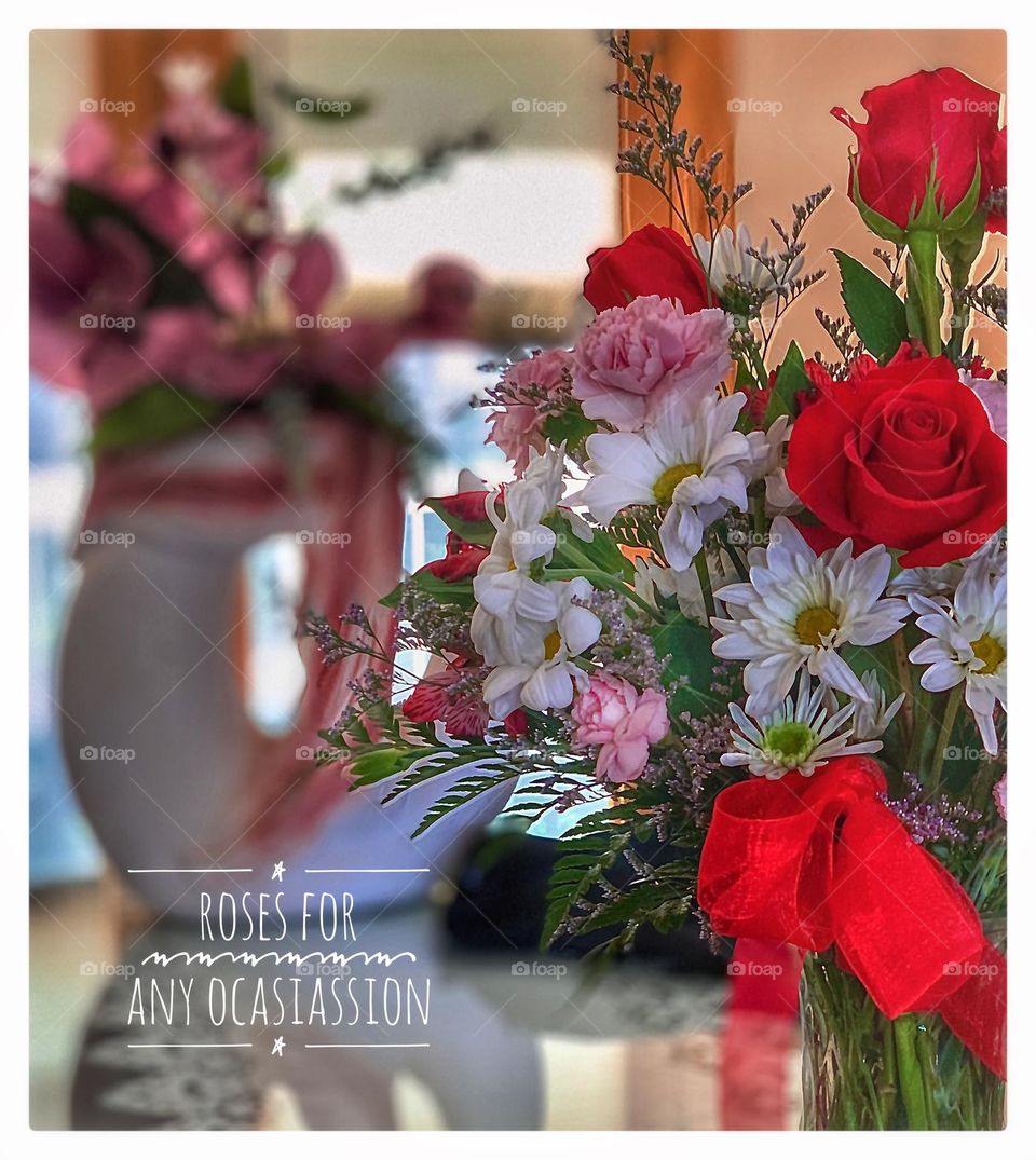 Beautiful red flowers in a vase in the foreground with great color and depth 