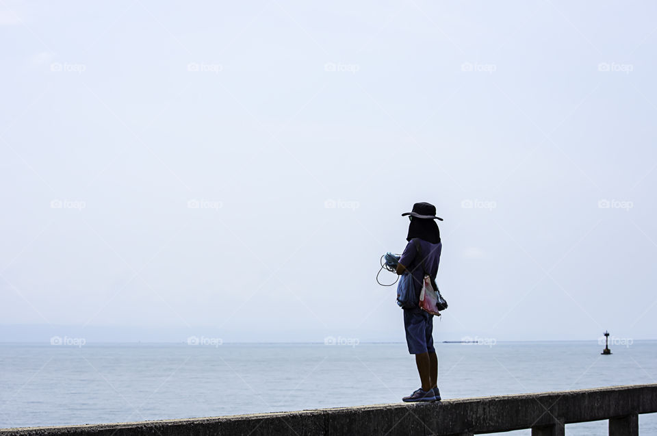 Man holding fishing nets  Background sea and sky.