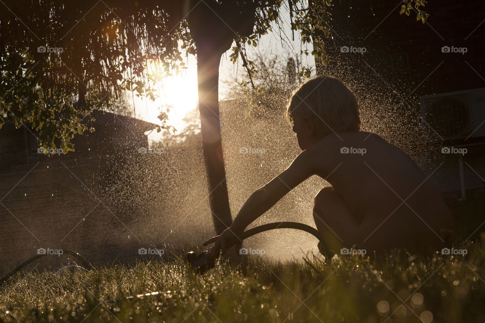 Little boy watering the garden 