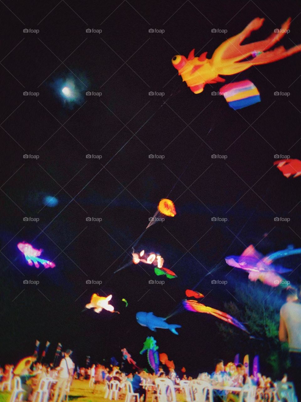 Kites flying in the sky at night.