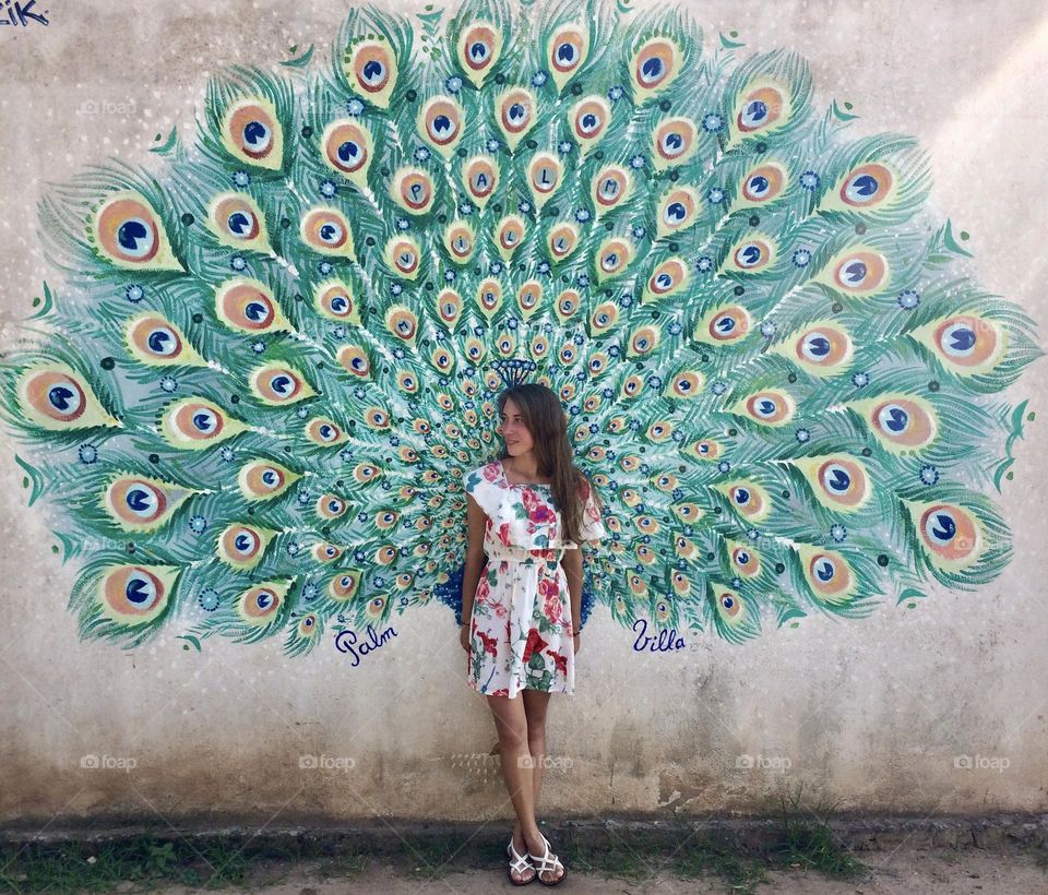 Young woman standing near the graffiti wall