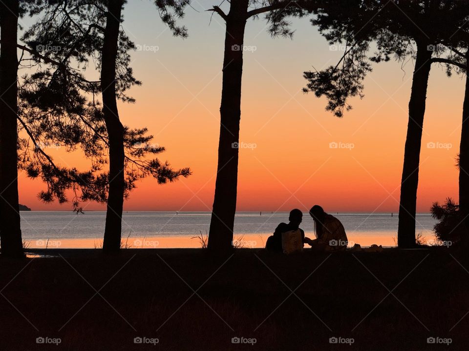 Couple by the sea at sunset