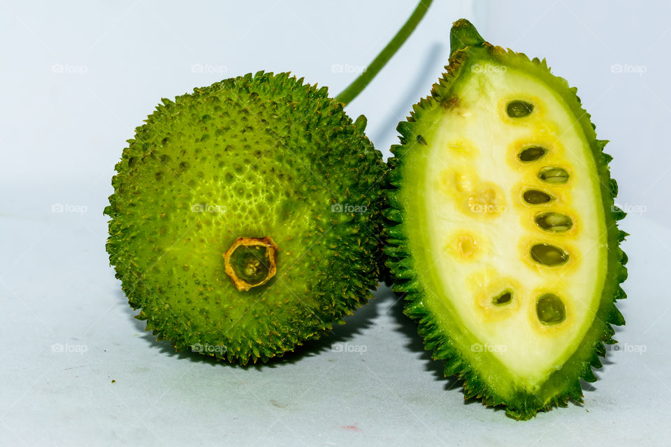Sri Lankan spiny green bitter gourd green fruit vegetable on white background.