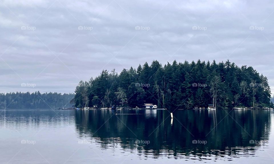 An overcast day blankets quaint Cox Island on American Lake, Washington in multiple shades of gray