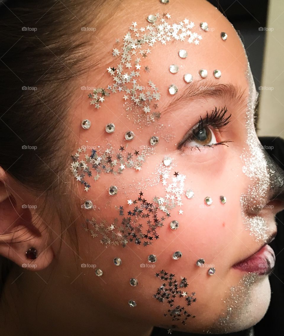 Close-up of a teenage girl with glitter makeup