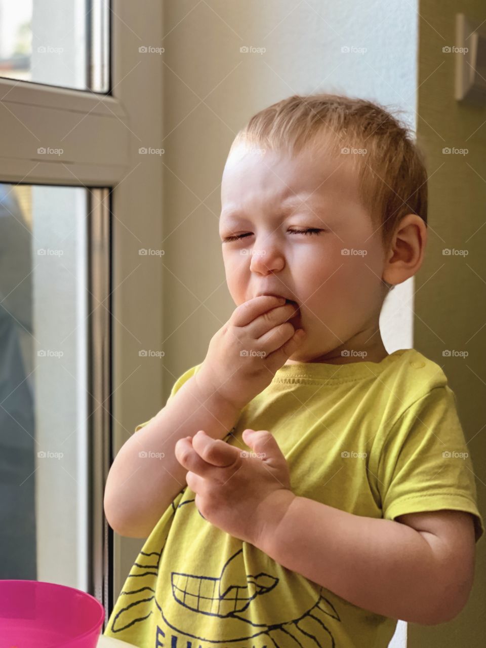 Little boy takes a bite with pleasure, toddler is eating