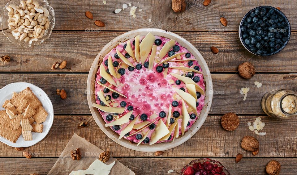 Top view of delicious cake with blueberries and white chocolatee on wooden boards