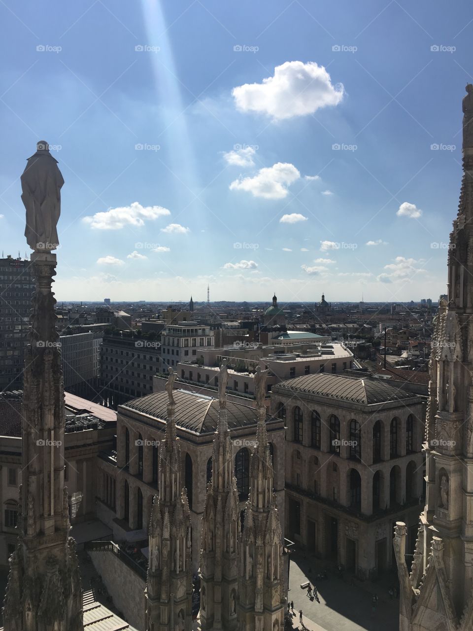 View of Milan from roof of Duomo-ray of light from sun to city