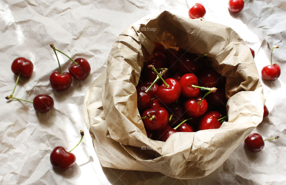 Cherries in a paper bag on a paper background