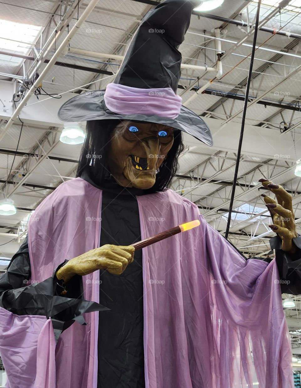 close up view of spooky 10 foot animatronic glowing Halloween witch decoration in an Oregon warehouse store