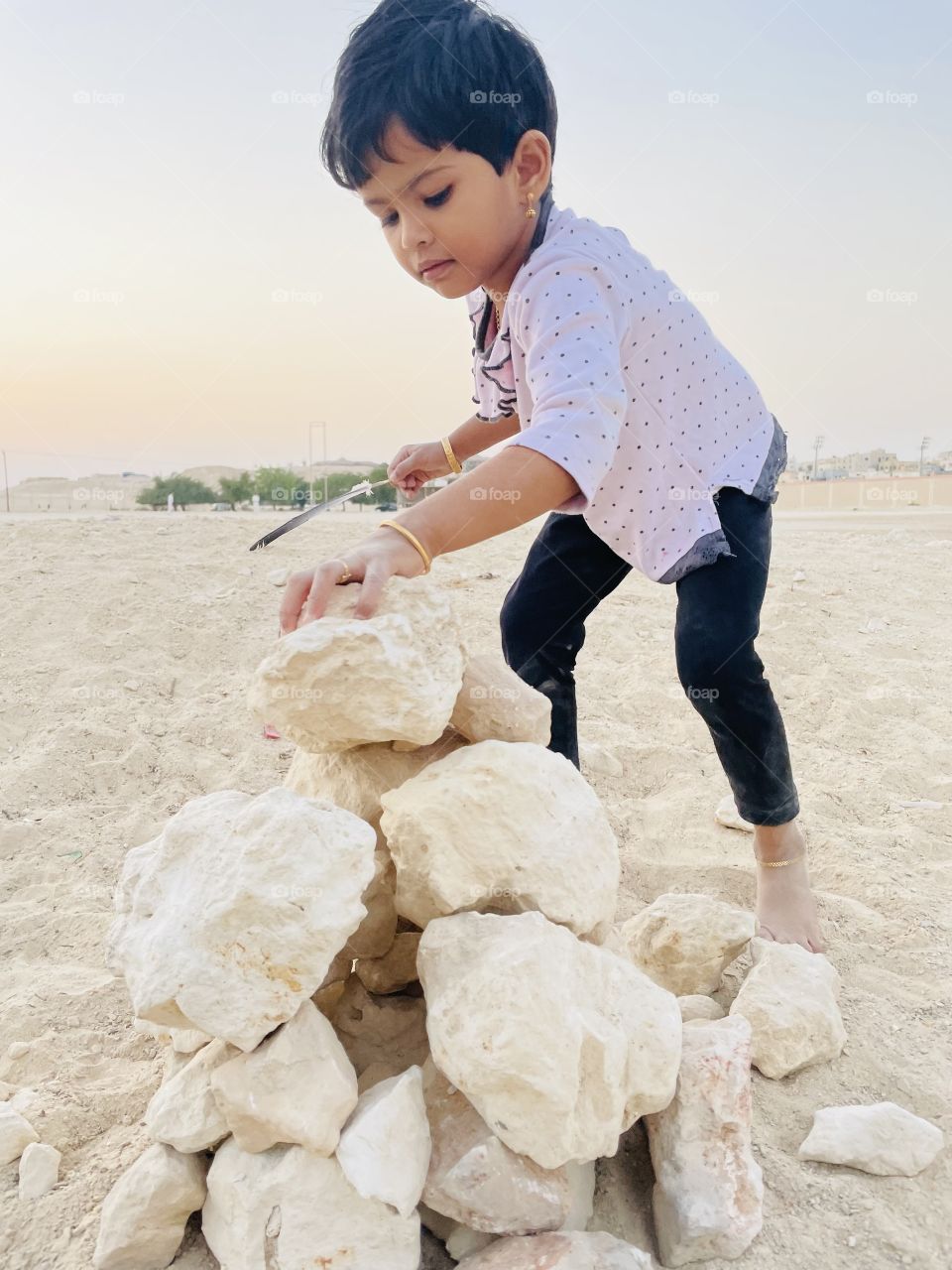 A child playing with stone, building home